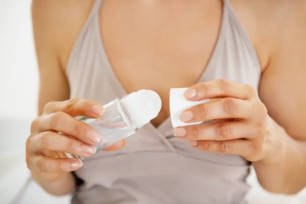 Woman holding roll on deodorant bottle